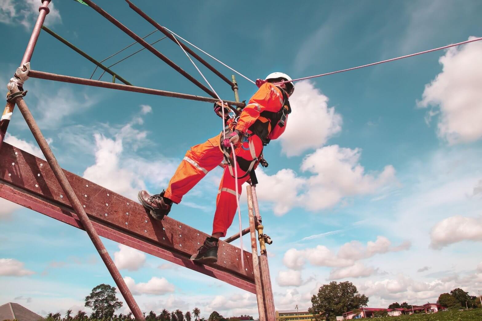 Construction worker with a safety harness while working from a height