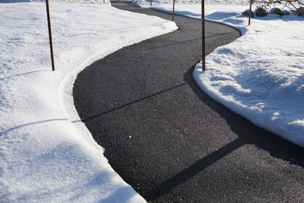 A winding sidewalk made safe and snow-free by a snow removal business