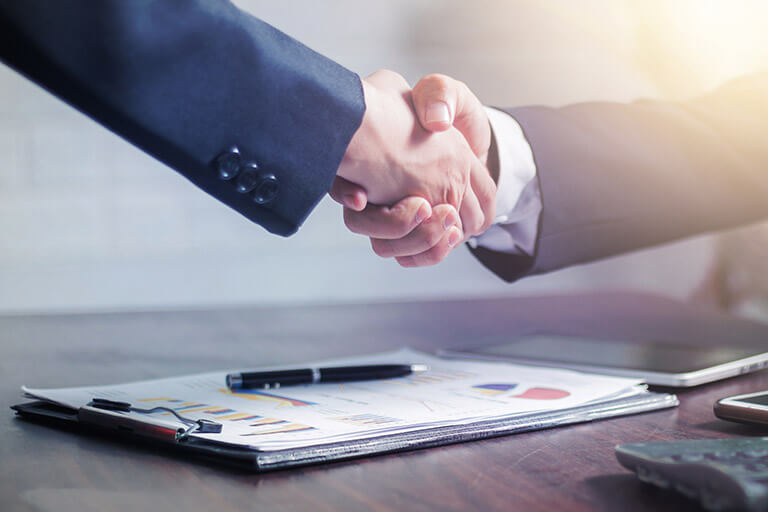 Two people shaking hands after agreeing on a construction bond