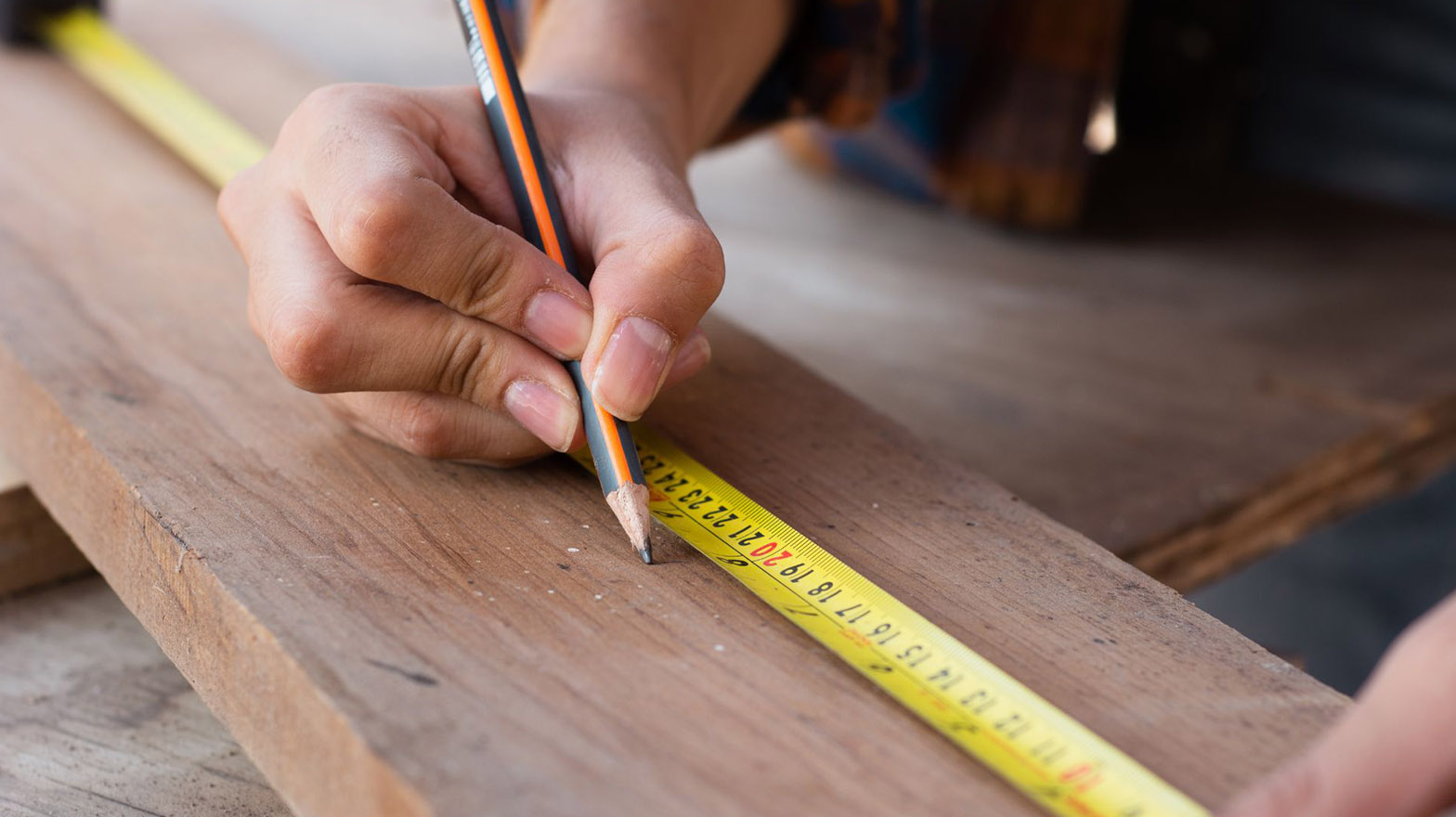 A man measuring a piece of wood