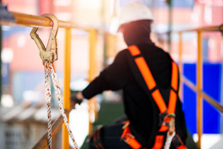 A construction worker on a scaffolding wearing a safety harness. 