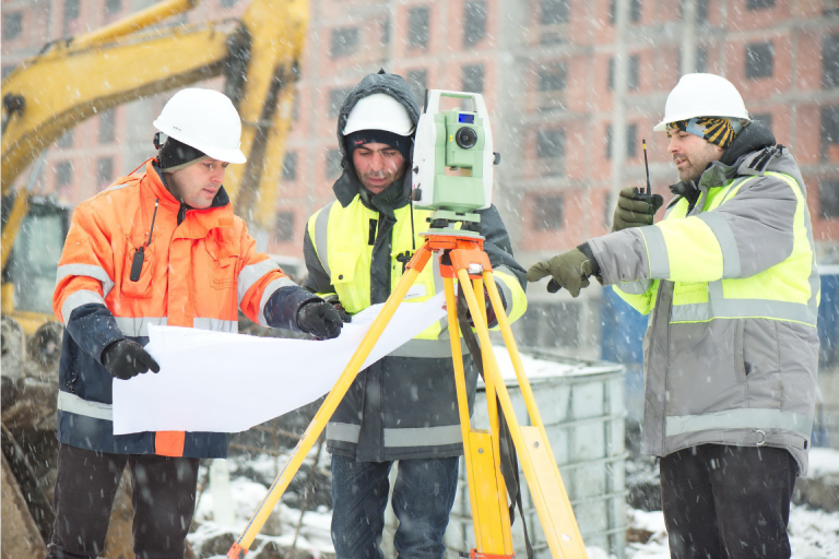 three contractors working in a snowstorm