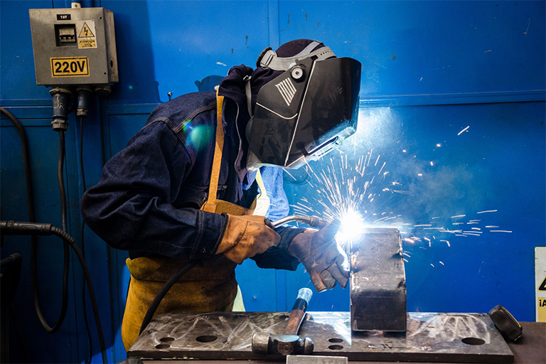 A contractor welding a piece of metal.

