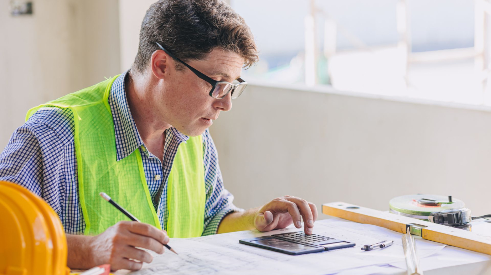 A contractor calculating their current construction costs.