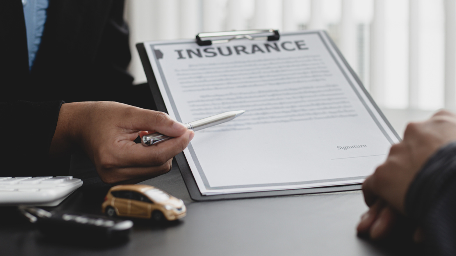 A insurance broker reviews an insurance agreement with a client