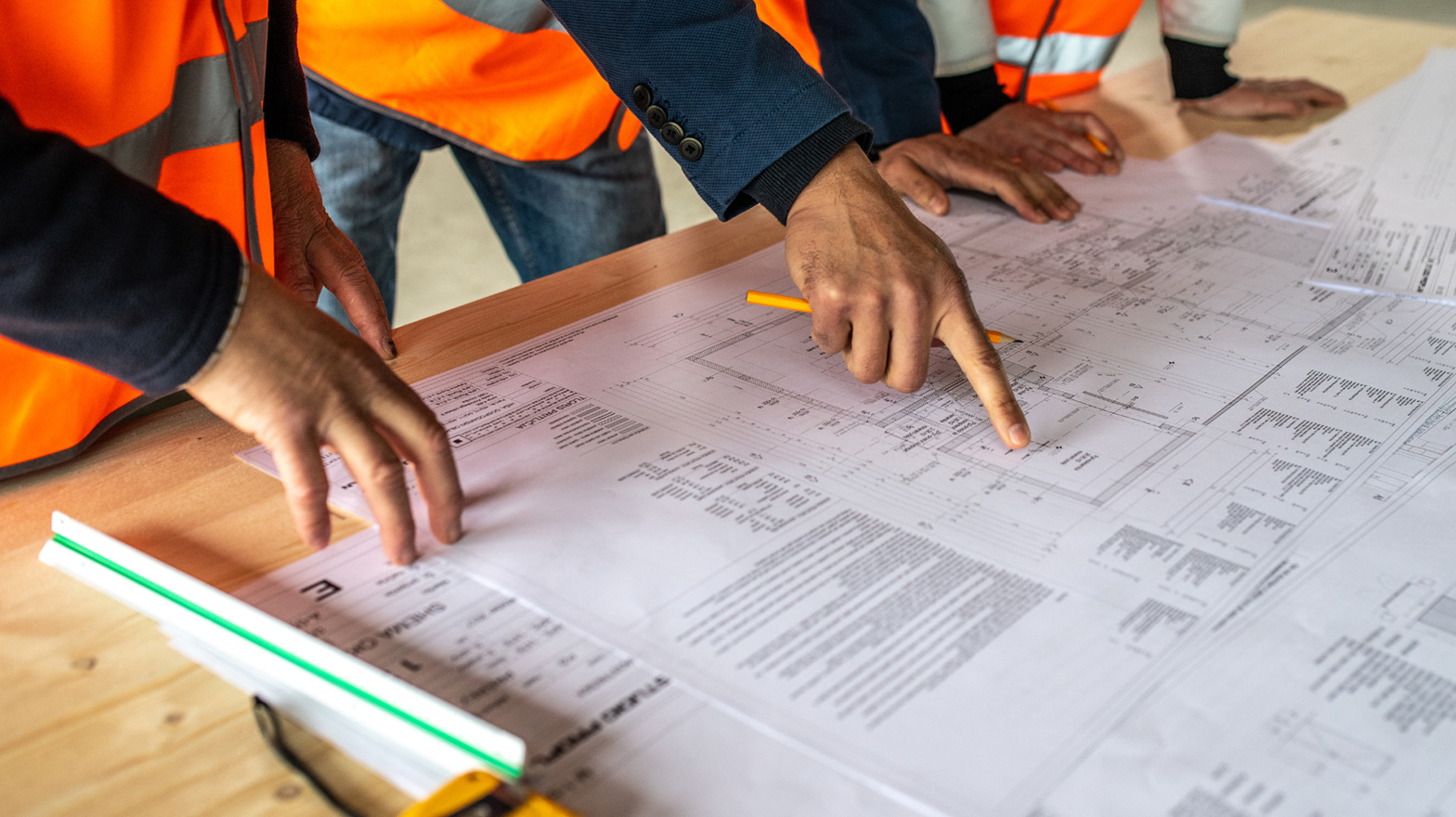 Contractor discussing change orders, looking at blueprints on a table