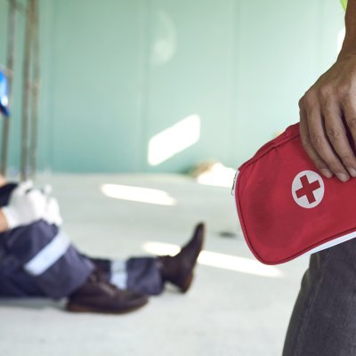 Worker bringing first aid kit to injured party