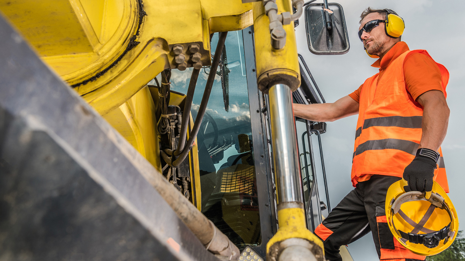 Heavy equipment operator getting inside leased heavy equipment