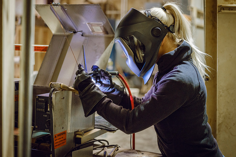 Welder working while wearing safety gear