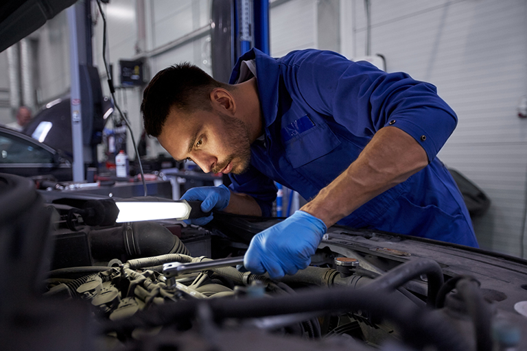 Industrial mechanic inspecting automotive engine