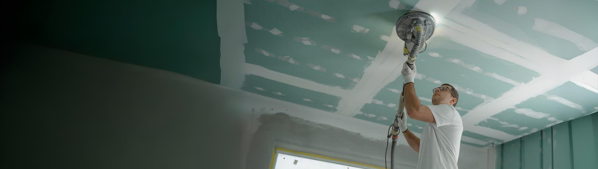 A drywall contractor finishing a ceiling