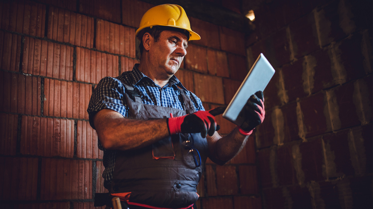 Contractor using the best trades app using a tablet on a job site